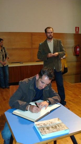 Mosquera asinando no libro de '120 anos de ciclismo galego'